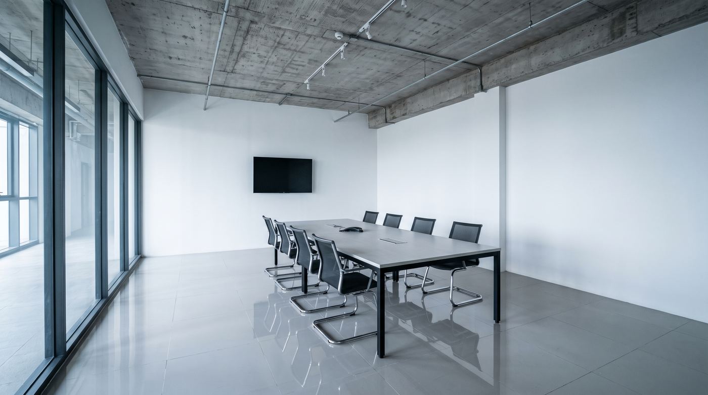 Meeting room with bare concrete ceiling and hard walls